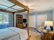 Bedroom with a rustic four poster bed, wood floors, a comfortable seating area and lots of storage at 343 Sweet Bay Ave, New Smyrna Beach, FL 32168