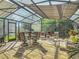 Relaxing enclosed patio area featuring outdoor dining, ample seating, and views of the lush yard at 343 Sweet Bay Ave, New Smyrna Beach, FL 32168