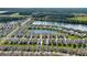 An aerial perspective of this community with lush green spaces and access to a serene lake at 349 Caryota Ct, New Smyrna Beach, FL 32168