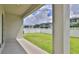 An inviting outdoor patio that shows the lawn with a white fence and neighborhood homes at 349 Caryota Ct, New Smyrna Beach, FL 32168