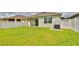Large backyard features a well-manicured lawn, privacy fence, and a covered patio for outdoor relaxation at 349 Caryota Ct, New Smyrna Beach, FL 32168