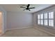 Spacious bedroom featuring a ceiling fan, neutral carpet, and bright window with plantation shutters at 349 Caryota Ct, New Smyrna Beach, FL 32168