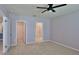 Bright bedroom with neutral carpet, ceiling fan, and doorways to the bathroom and walk-in closet at 349 Caryota Ct, New Smyrna Beach, FL 32168