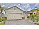Charming home featuring a two-car garage, brick accents, and a well-kept front yard with fresh landscaping at 349 Caryota Ct, New Smyrna Beach, FL 32168