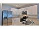 Well-equipped kitchen with stainless appliances, granite counters, and white cabinetry at 349 Caryota Ct, New Smyrna Beach, FL 32168