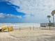 Beautiful beach view with white sand, blue skies, and a wooden walkway at 3606 S Peninsula Dr # 406, Port Orange, FL 32127