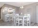 Dining area with white table, four chairs, and pendant lighting adjacent to kitchen with breakfast bar at 3606 S Peninsula Dr # 406, Port Orange, FL 32127