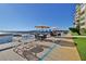 Community patio area with waterfront views, bar seating, dining tables, and tropical landscaping at 3606 S Peninsula Dr # 406, Port Orange, FL 32127
