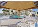 Community pool area with sun chairs, shade structure, and tropical landscaping under a sunny sky at 3606 S Peninsula Dr # 406, Port Orange, FL 32127