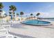 Resort-style pool area with palm trees, lounge chairs, and waterfront views for ultimate relaxation at 3606 S Peninsula Dr # 406, Port Orange, FL 32127