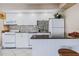 This kitchen offers bright white cabinets, tiled backsplash and full sized appliances at 3700 S Atlantic Ave # 108, New Smyrna Beach, FL 32169