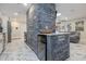 Bright kitchen with stylish marble floors, a stone breakfast bar, and stainless steel appliances open to the living area at 38 Fairway Cir, New Smyrna Beach, FL 32168