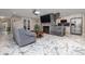 Stylish living room with a cozy sofa, modern fireplace, and seamless kitchen access at 38 Fairway Cir, New Smyrna Beach, FL 32168