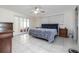 Serene bedroom with a comfortable bed, classic wood furnishings, and bright natural light from a large window at 38 Fairway Cir, New Smyrna Beach, FL 32168