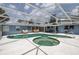An eye-level shot of the enclosed pool and jacuzzi, with ample seating and a well maintained patio area at 38 Fairway Cir, New Smyrna Beach, FL 32168