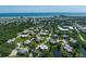 Aerial view of a coastal community featuring lush landscaping, serene pond, and the ocean in the background at 3824 Saxon Dr, New Smyrna Beach, FL 32169