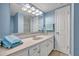 Bathroom featuring a vanity with storage, decorative mirror, and modern fixtures for a serene experience at 3824 Saxon Dr, New Smyrna Beach, FL 32169