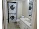 Bathroom featuring a stacked washer and dryer, white vanity, and tile flooring at 3824 Saxon Dr, New Smyrna Beach, FL 32169