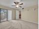Bedroom featuring a ceiling fan, closet and a balcony door offering scenic views and natural light at 3824 Saxon Dr, New Smyrna Beach, FL 32169