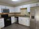 A well-lit kitchen with stainless steel appliances, tile backsplash, and white cabinetry at 3824 Saxon Dr, New Smyrna Beach, FL 32169