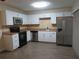 A kitchen with white cabinets, stainless steel appliances, and a tile backsplash at 3824 Saxon Dr, New Smyrna Beach, FL 32169