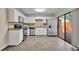 White kitchen with stainless steel appliances, tile backsplash, and sliding glass doors to the backyard at 3824 Saxon Dr, New Smyrna Beach, FL 32169