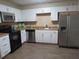 A kitchen with white cabinets, stainless steel appliances, and a tile backsplash at 3824 Saxon Dr, New Smyrna Beach, FL 32169