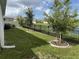 Spacious backyard with a black iron fence, mature trees, and serene pond views at 3919 Willowbrook Dr, Edgewater, FL 32141