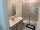 Modern bathroom featuring a glass-door shower, vanity with sink, and neutral tile flooring at 3919 Willowbrook Dr, Edgewater, FL 32141