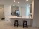 Open-concept kitchen features gray cabinets, quartz countertops, an island with bar stool seating and stainless appliances at 3919 Willowbrook Dr, Edgewater, FL 32141