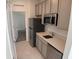 Efficient kitchenette with stainless steel appliances and gray cabinets at 3919 Willowbrook Dr, Edgewater, FL 32141