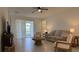 Bright living room features modern furnishings, a ceiling fan, and sliding door access to a covered patio or balcony at 3919 Willowbrook Dr, Edgewater, FL 32141