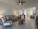 Cozy living room with neutral tones, comfortable seating, ceiling fan, and open access to the dining area and kitchen at 3919 Willowbrook Dr, Edgewater, FL 32141