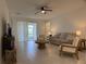 Bright living room features modern furnishings, a ceiling fan, and sliding door access to a covered patio or balcony at 3919 Willowbrook Dr, Edgewater, FL 32141