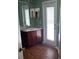 Bathroom features a wooden vanity, mirrored cabinet, and a door leading to the outside at 405 Central Mariners Dr, Edgewater, FL 32141