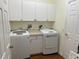Laundry room with white washer and dryer and ample storage cabinets at 405 Central Mariners Dr, Edgewater, FL 32141