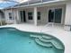 Inviting screened-in pool with steps into the water with views to the rear of the property at 405 Central Mariners Dr, Edgewater, FL 32141
