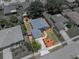 Aerial view of a gray single-Gathering home with a fenced backyard, landscaped yard and a two-car garage at 411 Ryans Ridge Ave, Eustis, FL 32726