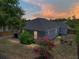 Backyard view at dusk, featuring a patio, lush lawn, and cozy fire pit area at 411 Ryans Ridge Ave, Eustis, FL 32726