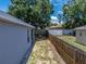 Side yard featuring a wood fence providing privacy, grass and a tidy garden bed at 411 Ryans Ridge Ave, Eustis, FL 32726