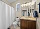 Well-lit bathroom features a toilet, vanity, and a shower with a white curtain at 411 Ryans Ridge Ave, Eustis, FL 32726
