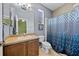 Well-lit bathroom featuring a toilet, vanity, and a shower with a blue patterned curtain at 411 Ryans Ridge Ave, Eustis, FL 32726