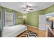 Cozy bedroom features a ceiling fan, window with blinds, and light hardwood flooring at 411 Ryans Ridge Ave, Eustis, FL 32726