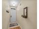 Neutral entryway featuring a door, hooks, mirror, and tiled flooring with a rug at 411 Ryans Ridge Ave, Eustis, FL 32726