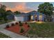 The house has beautiful landscaping, a garage and a striking red front door at 411 Ryans Ridge Ave, Eustis, FL 32726