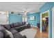 Cozy living room with hardwood floors, an extra large couch, fan, television and colorful wall art at 411 Ryans Ridge Ave, Eustis, FL 32726