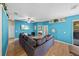 The living room is an open design with hardwood floors, fan, television, a couch and colorful walls at 411 Ryans Ridge Ave, Eustis, FL 32726