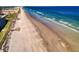 A scenic view of a beach with clear blue water and condos nearby at 4141 S Atlantic Ave # 605, New Smyrna Beach, FL 32169