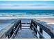 Inviting beach access point showcasing wooden steps leading down to the sandy shore and blue ocean waters at 4141 S Atlantic Ave # 605, New Smyrna Beach, FL 32169