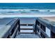 Stairs lead down to a beautiful beach with rolling waves and a serene ocean view, perfect for relaxation at 4141 S Atlantic Ave # 605, New Smyrna Beach, FL 32169